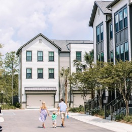 A family walking on a street surrounded by houses
